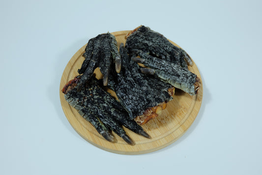 Dehydrated crocodile feet for dogs displayed on a round wooden plate – single-ingredient pet treat