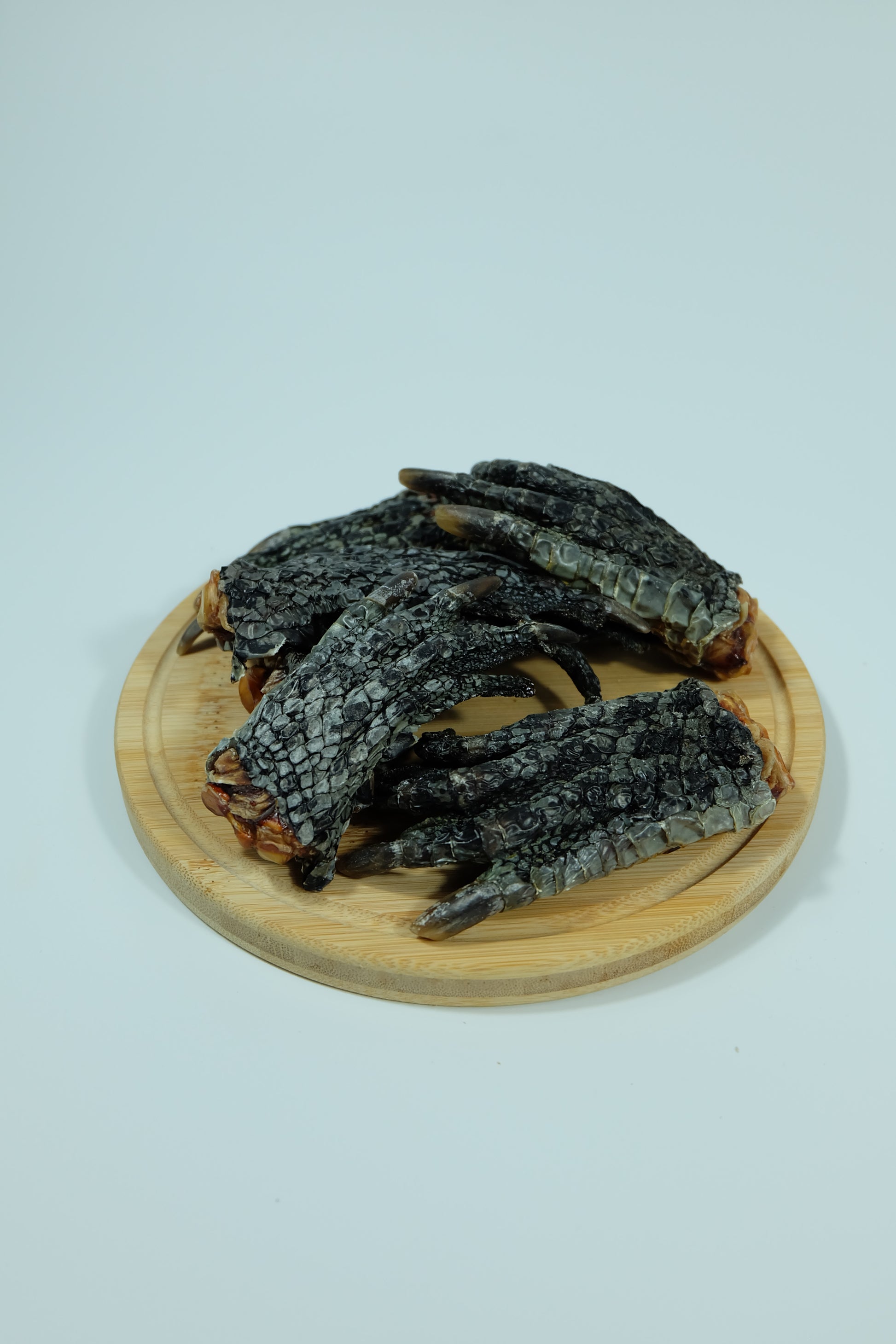 Top view of crocodile feet dog treats on a wooden plate – hypoallergenic, natural Australian chew