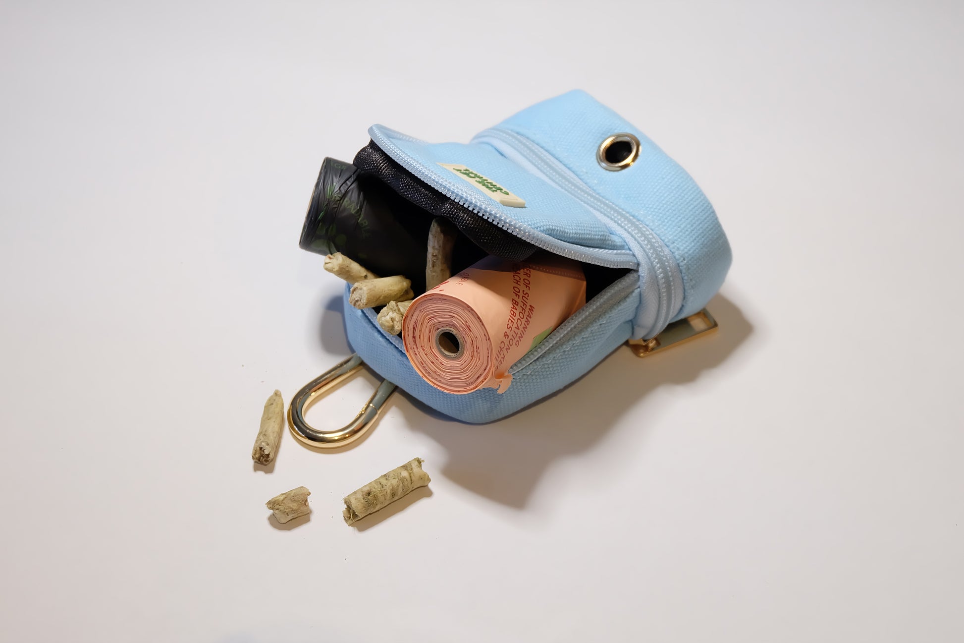 The Pet Central - The Paw Pack in Blue with an Open Top Compartment Showing Poop Bag Rolls and Treats