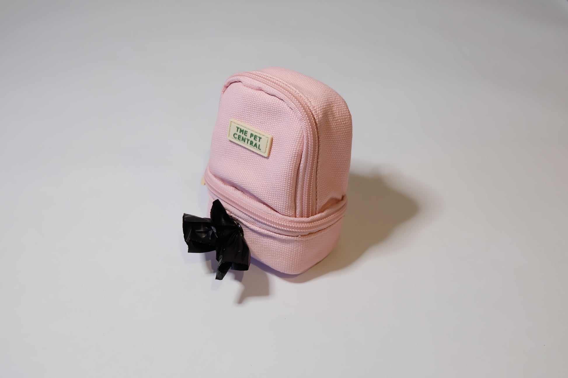 The Pet Central - The Paw Pack in Pink with a Poop Bag Appearing Through the Poop Bag Holder Compartment