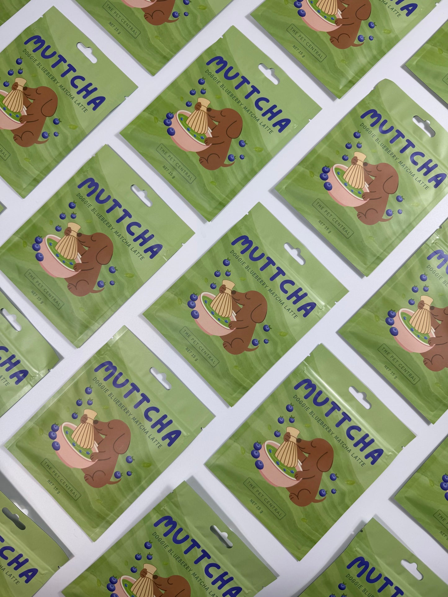 Multiple Blueberry Muttcha doggie blueberry matcha latte sachets arranged in a flat lay pattern