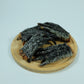 Top view of crocodile feet dog treats on a wooden plate – hypoallergenic, natural Australian chew
